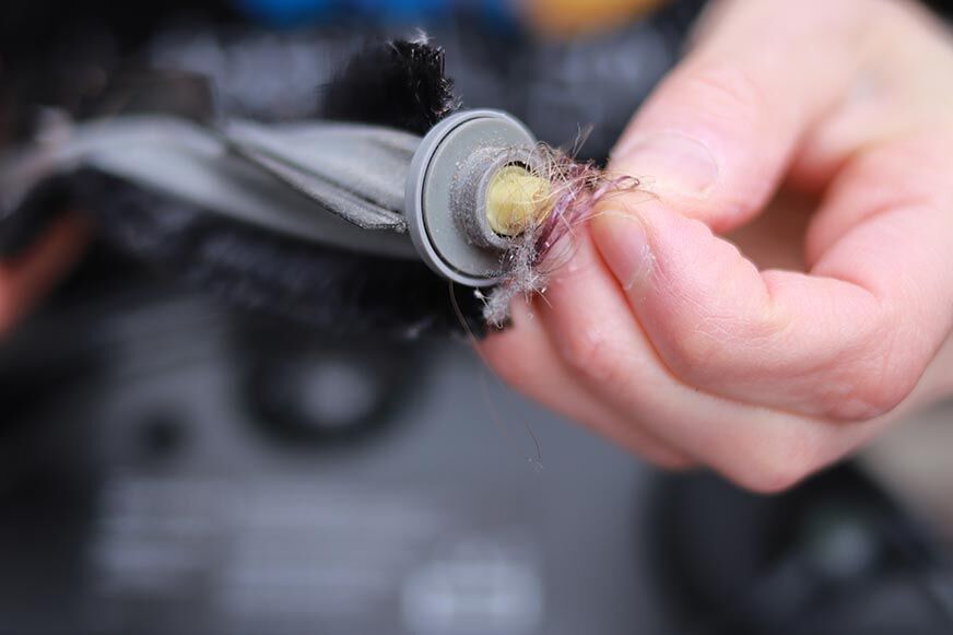 Man sieht, wie sich Haare um die Bürste des Ecovacs Deebot X1 OMNI gewickelt haben.